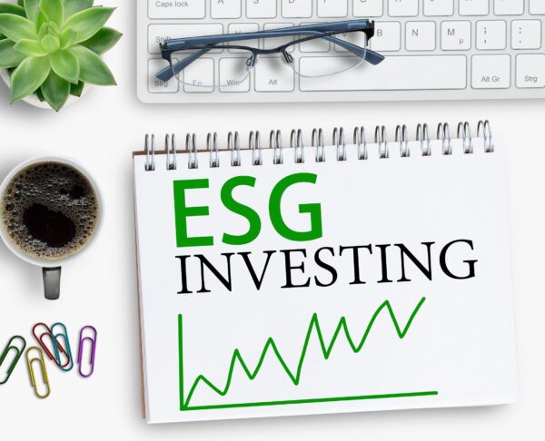 ESG investing results sign on notebook with keyboard and coffee,
